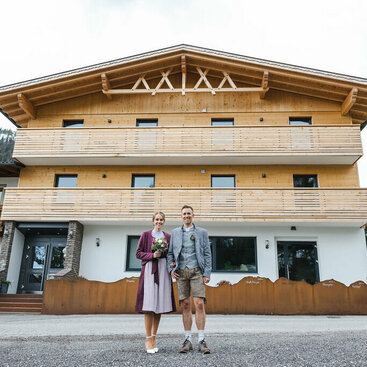 Gastgeber stehen vor dem Appartementhaus